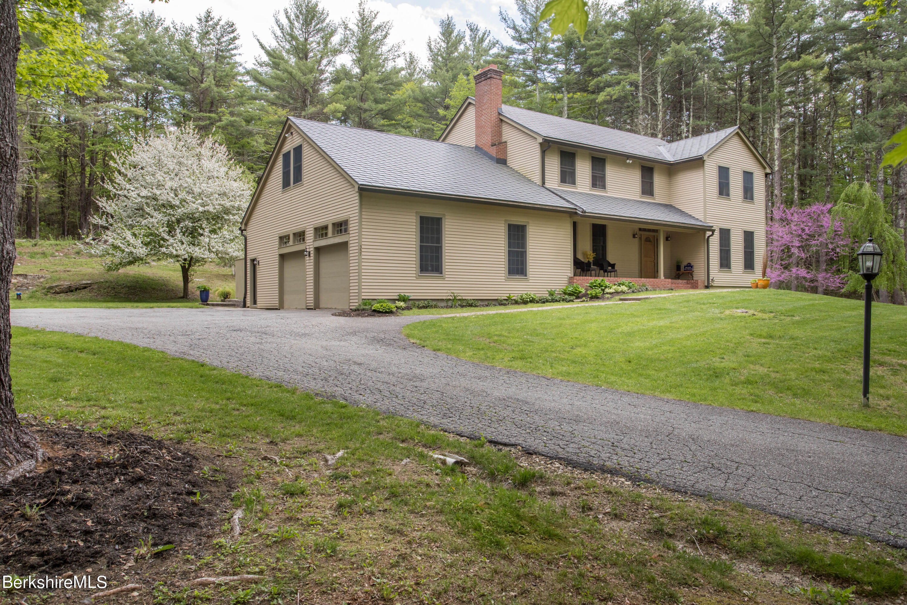 a front view of a house with a yard and trees