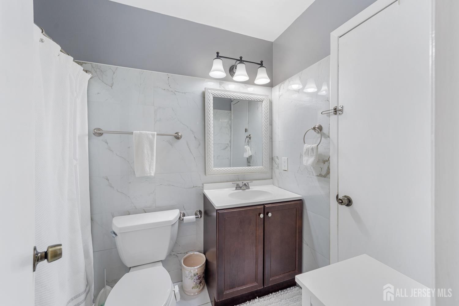 91 Redbud Road Piscataway, NJ 08854 - Photo 7 of 22 a bathroom with a toilet a sink and mirror