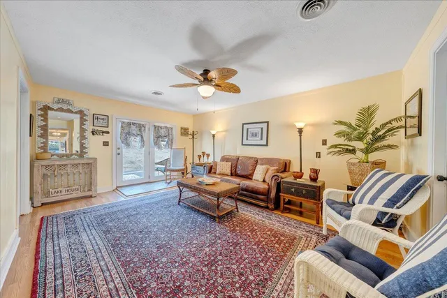 a view of a house with a small yard and large trees