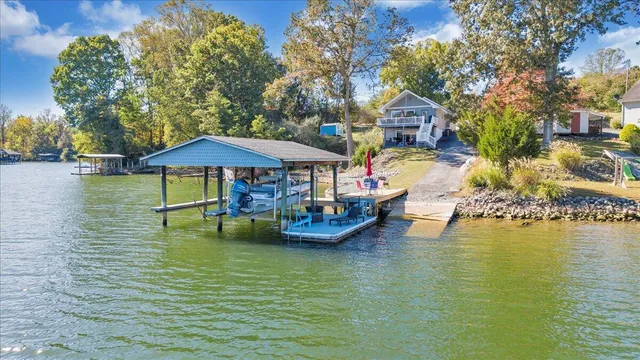 a front view of a house with garden and trees
