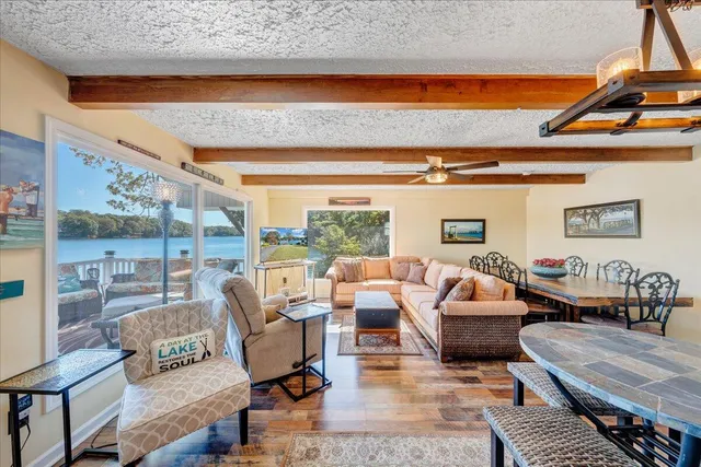 a dining room with furniture large windows and wooden floor