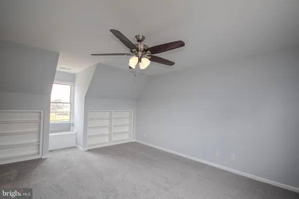 a view of an empty room and a ceiling fan
