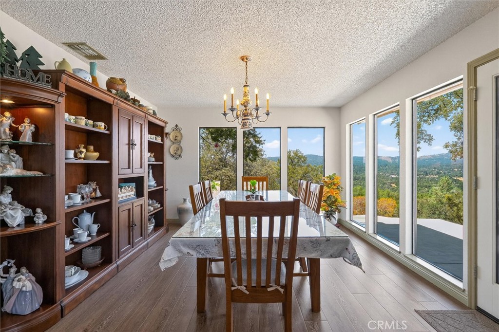 4870 Streeter Mountain Road Mariposa, CA 95338 - Photo 13 of 45 a view of a dining room with furniture large windows and wooden floor