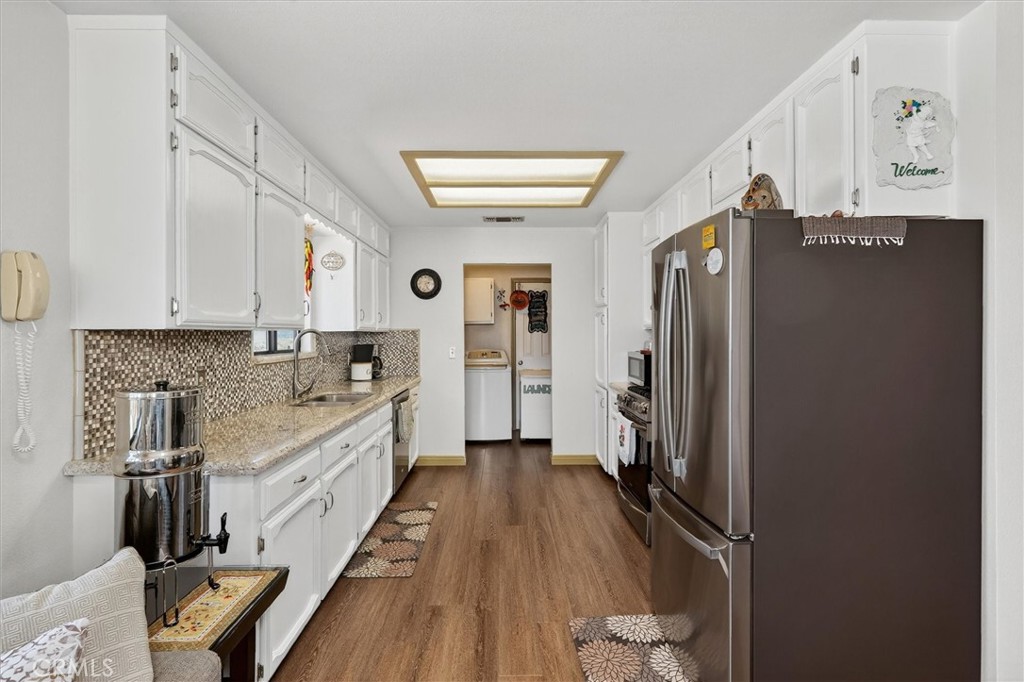 4870 Streeter Mountain Road Mariposa, CA 95338 - Photo 15 of 45 a large kitchen with a refrigerator a sink and dishwasher a refrigerator with wooden floor