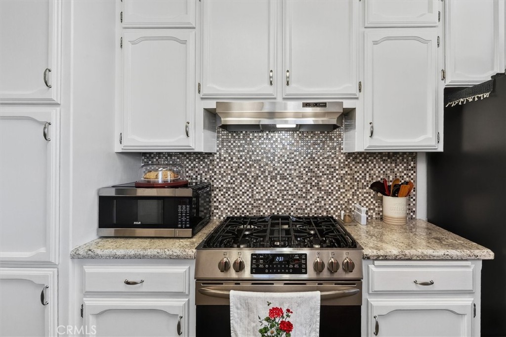 4870 Streeter Mountain Road Mariposa, CA 95338 - Photo 17 of 45 a kitchen with a stove and white cabinets