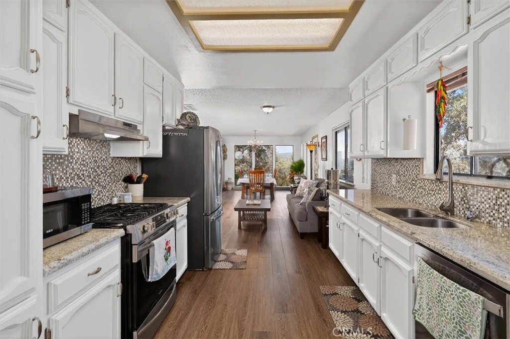 4870 Streeter Mountain Road Mariposa, CA 95338 - Photo 18 of 45 a kitchen with granite countertop lots of counter top space a sink appliances and cabinets