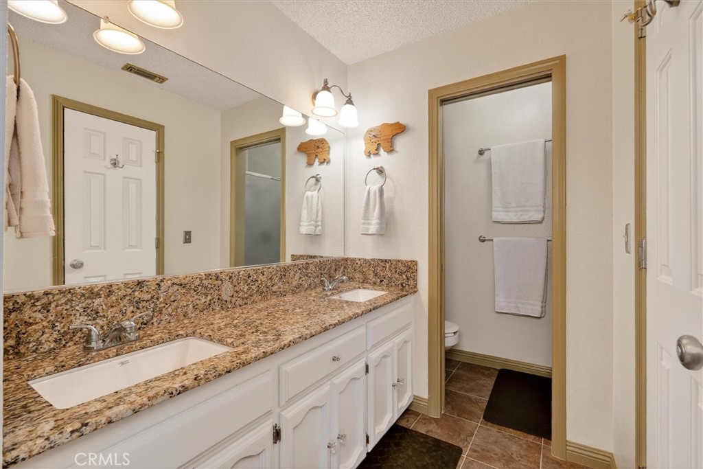 4870 Streeter Mountain Road Mariposa, CA 95338 - Photo 23 of 45 a bathroom with a granite countertop sink and a mirror
