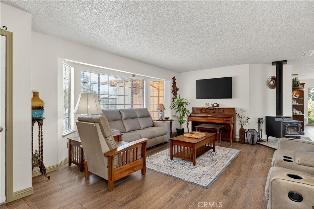 4870 Streeter Mountain Road Mariposa, CA 95338 - Photo 7 of 45 a living room with furniture and a flat screen tv with wooden floor