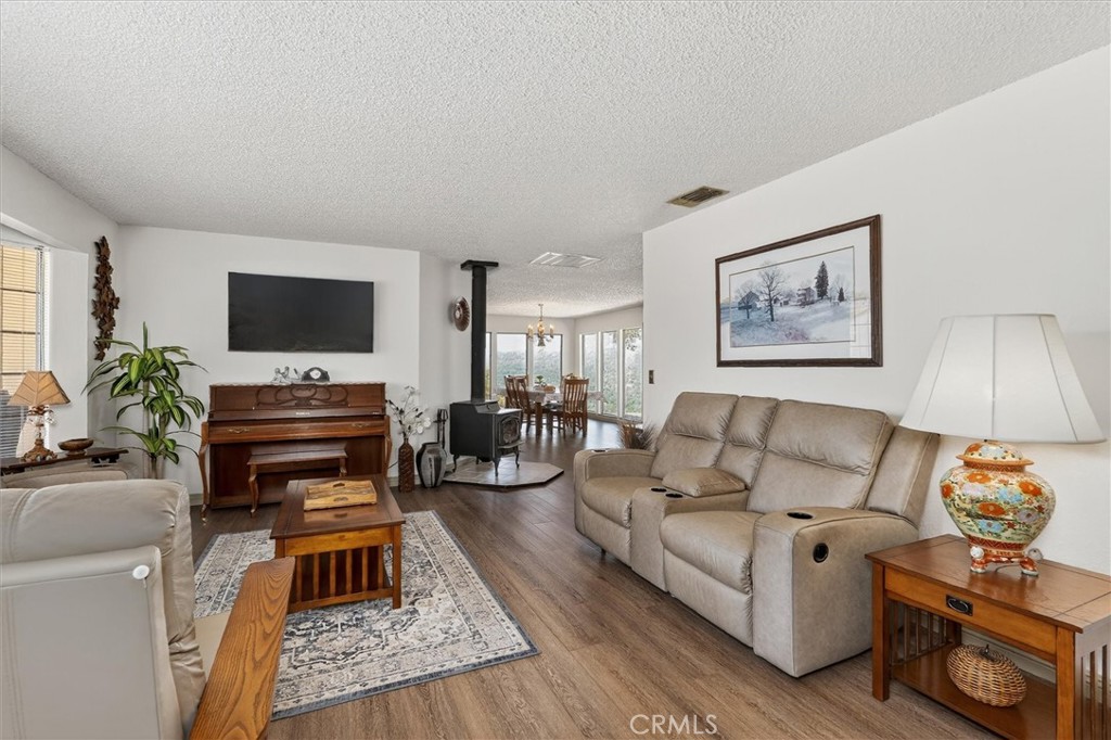 4870 Streeter Mountain Road Mariposa, CA 95338 - Photo 10 of 45 a living room with furniture and a flat screen tv with wooden floor
