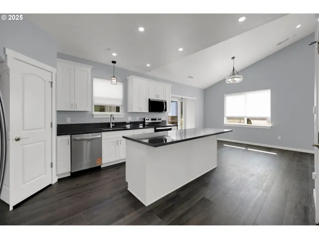 a kitchen with granite countertop a stove top oven and cabinets