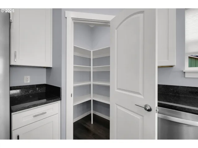 a kitchen with white cabinets and black appliances