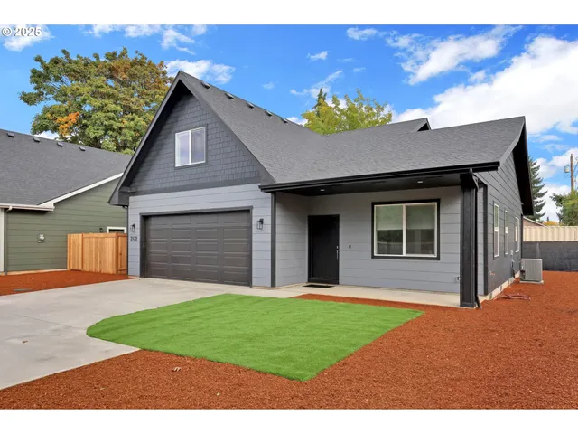 a front view of a house with a garden and yard