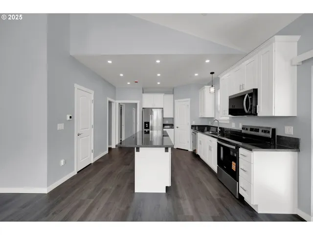 a living room with stainless steel appliances kitchen island wooden floor and view living room