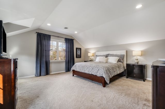 a spacious bedroom with a bed and a flat screen tv