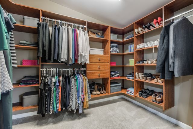 a view of walk in closet with clothes and shoes