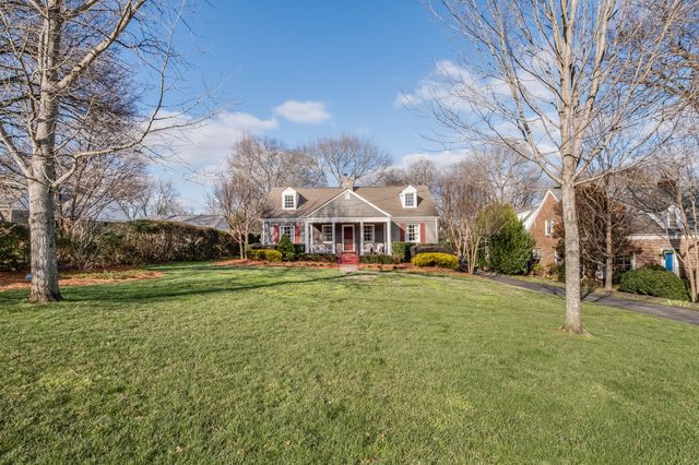 a view of a house with a big yard and large trees