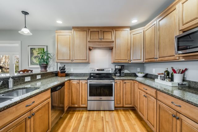 a kitchen with stainless steel appliances granite countertop a stove and a sink