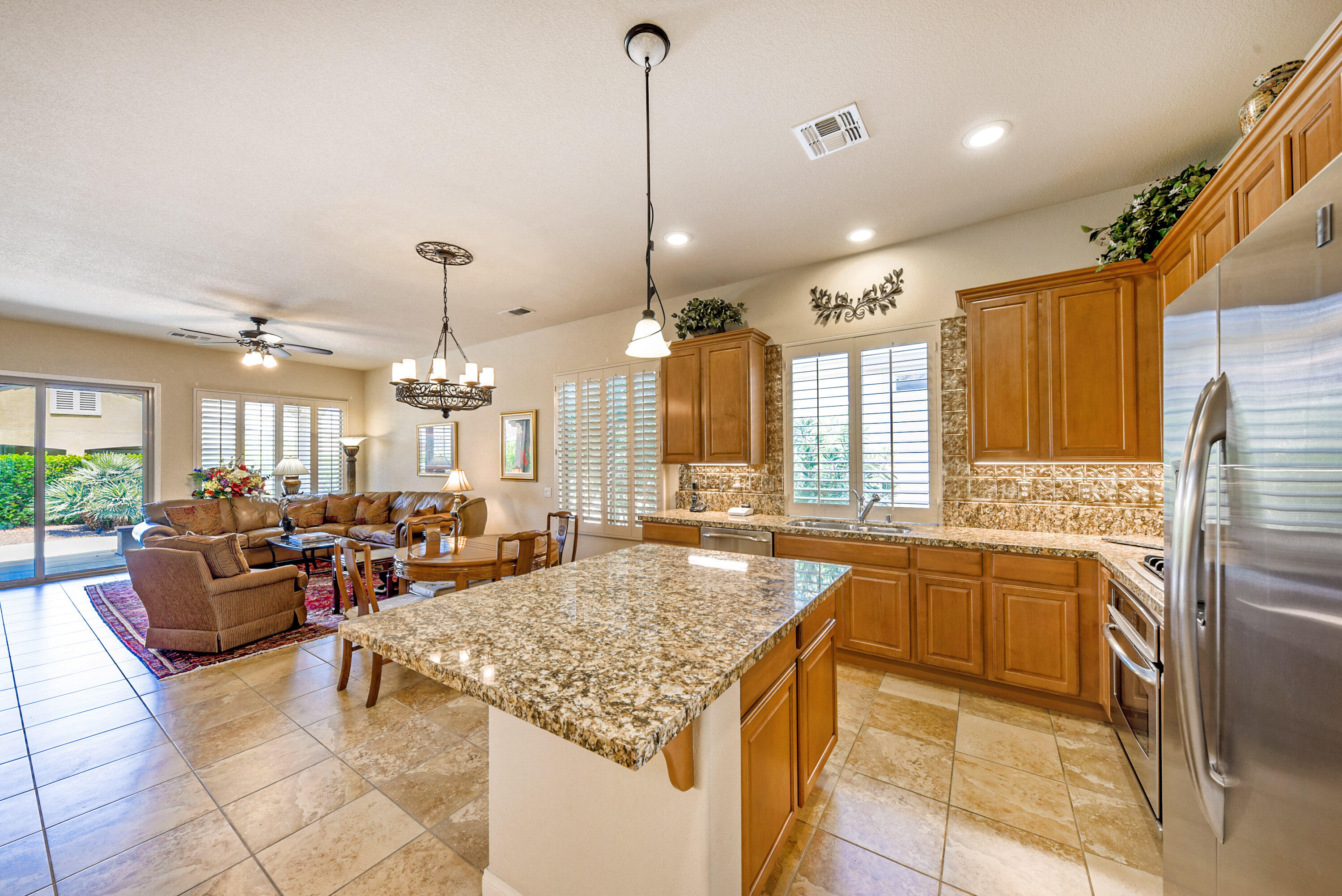 a large kitchen with kitchen island granite countertop a large center island attached withe living room