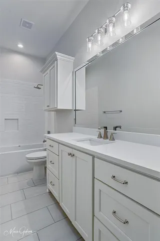 a bathroom with a sink a large mirror and a bathtub