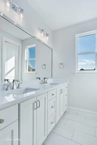 a bathroom with double sink and a mirror