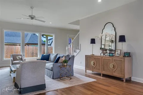 a living room with furniture a chandelier and wooden floor