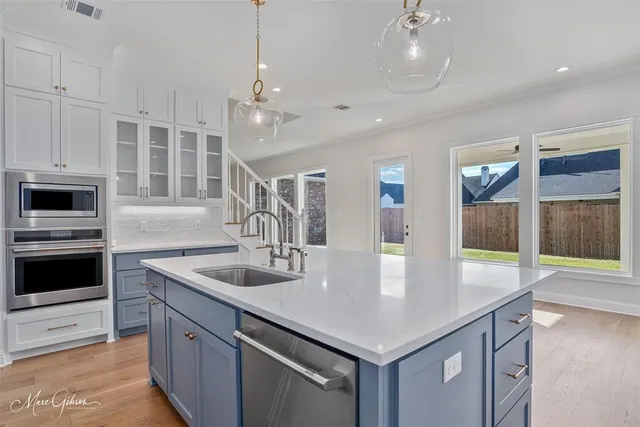 a kitchen with stainless steel appliances granite countertop a kitchen island a stove and a sink