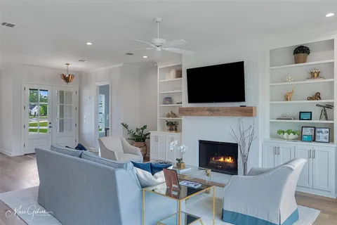 a living room with furniture a flat screen tv and a fireplace