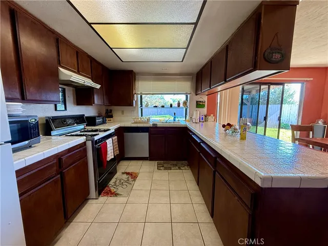 a kitchen with stainless steel appliances granite countertop a sink stove and cabinets
