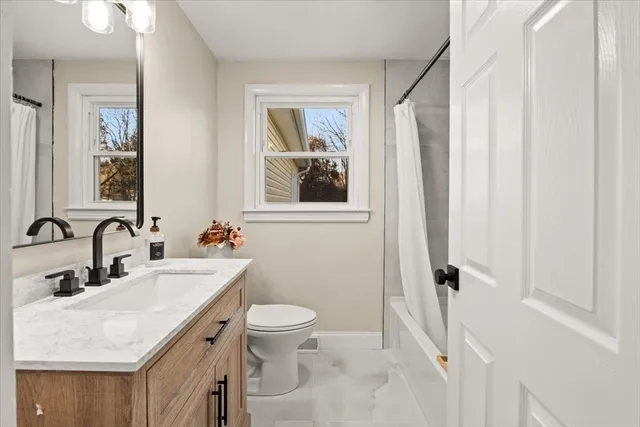 a bathroom with a sink vanity mirror and toilet
