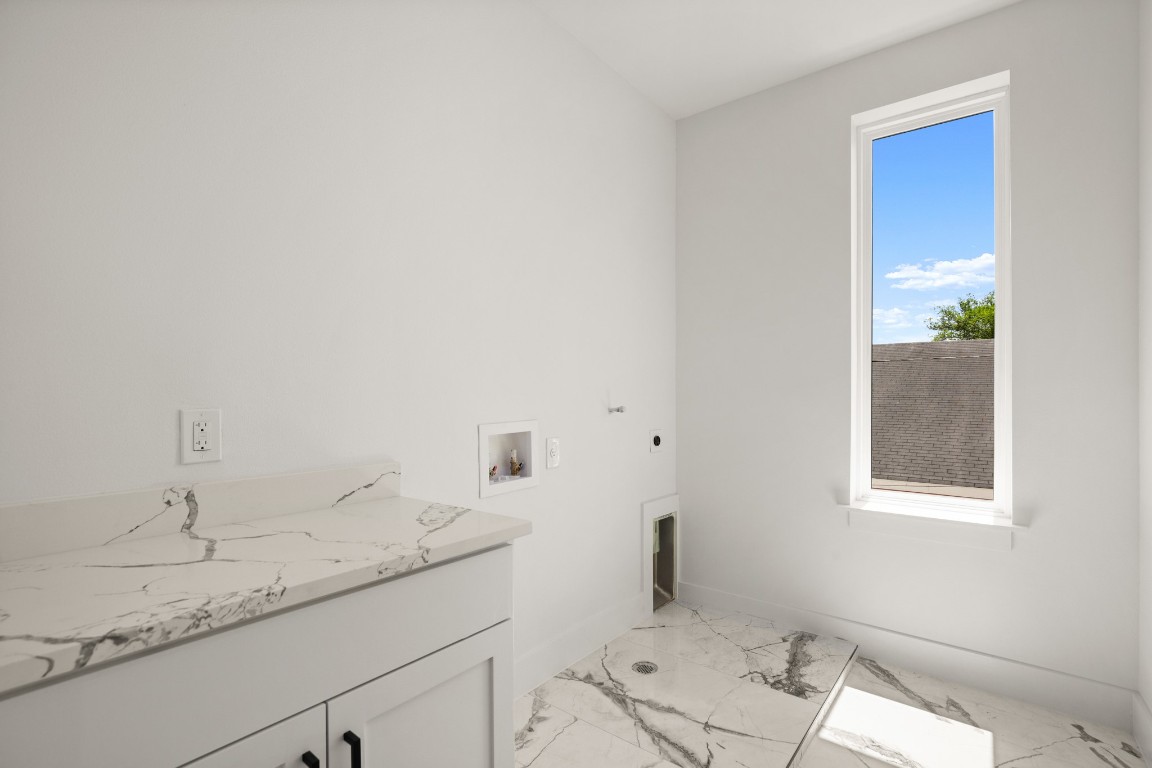 1606 Harvey Street, Unit 1 Austin, TX 78702 - Photo 19 of 33 a bathroom with a granite countertop sink and white cabinets