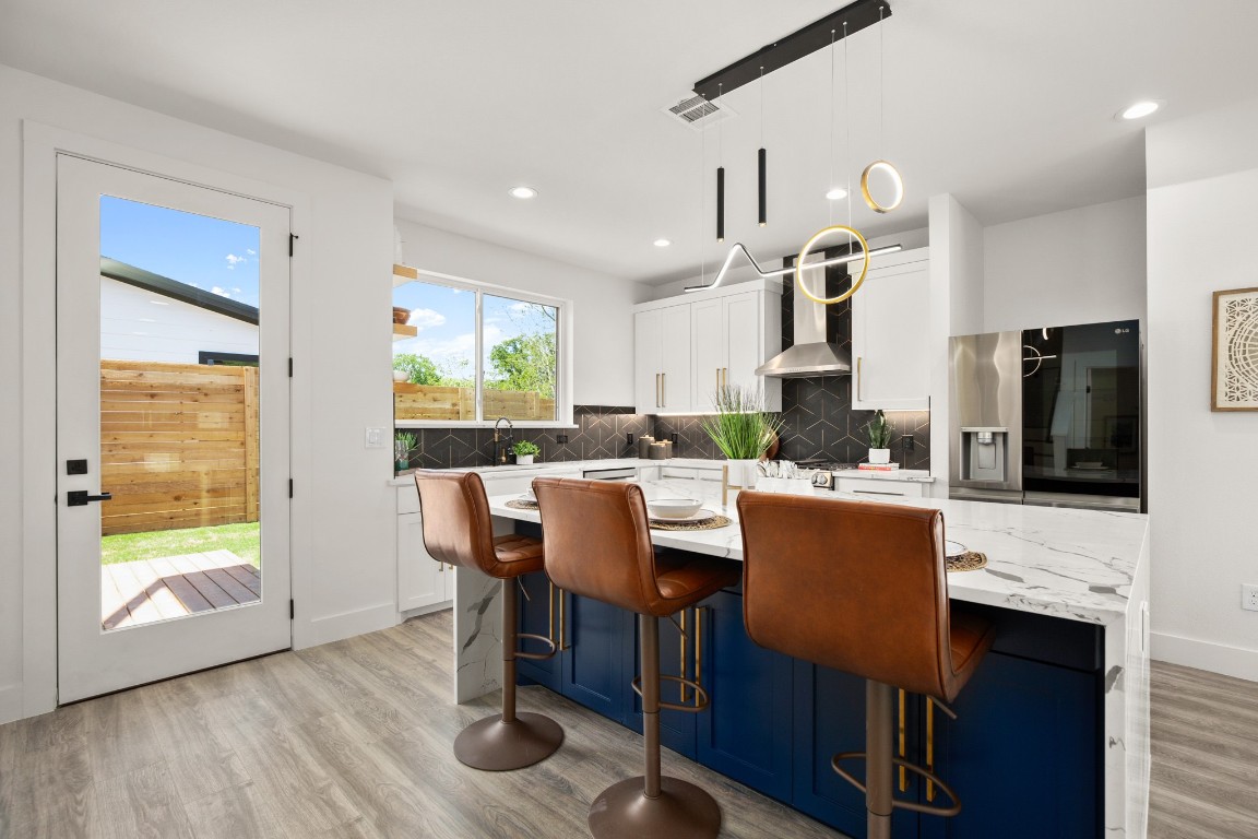 1606 Harvey Street, Unit 1 Austin, TX 78702 - Photo 8 of 33 a kitchen with stainless steel appliances granite countertop a stove a refrigerator a kitchen island a table and chairs in it