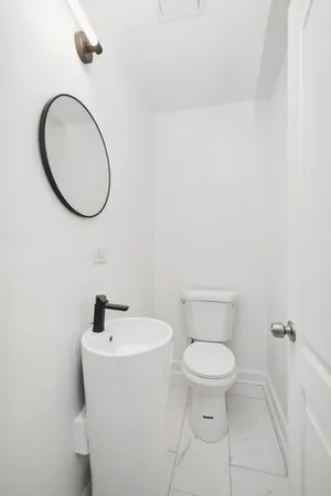 a white toilet sitting next to a bathroom sink