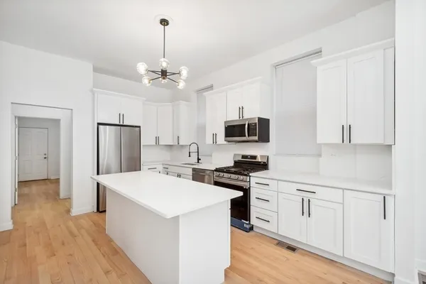 a kitchen with white cabinets and stainless steel appliances