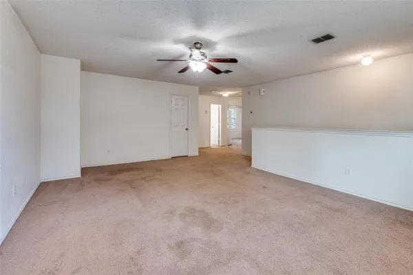 a view of an empty room and a ceiling fan