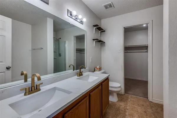 a bathroom with a sink double vanity and a toilet
