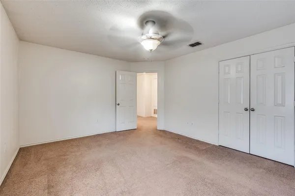 a view of an empty room with a chandelier fan