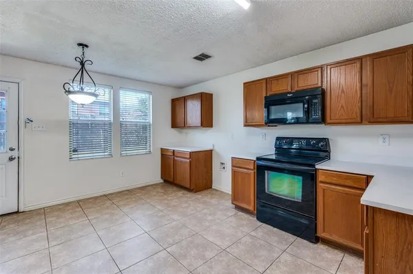 a kitchen with stainless steel appliances granite countertop a stove a sink dishwasher and a microwave oven on the blue kitchen countertops
