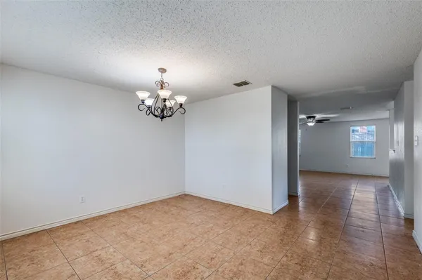 wooden floor in an empty room with a chandelier