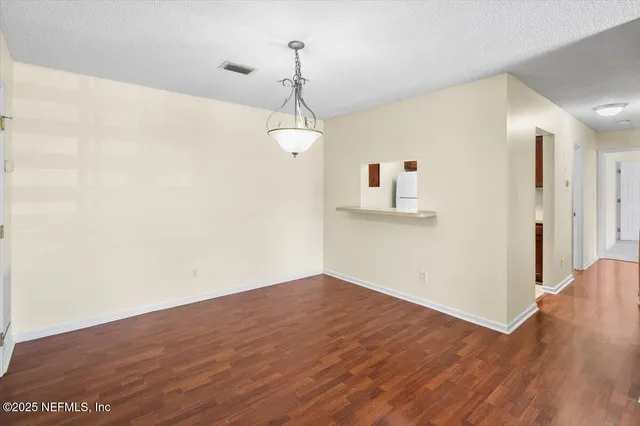 a view of empty room with wooden floor and ceiling fan