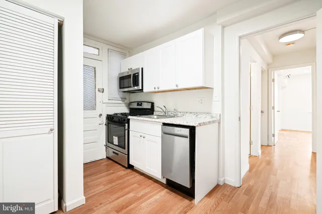 a kitchen with white cabinets and stainless steel appliances