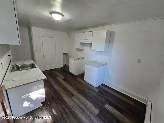 a living room with a couch and a stove with wooden floor