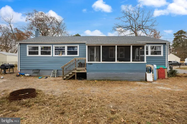 a view of a house with a patio and a yard