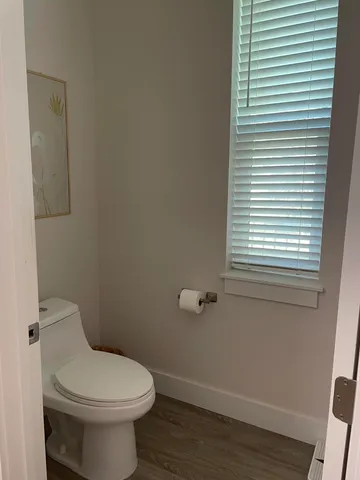 a bathroom with a granite countertop toilet sink and mirror