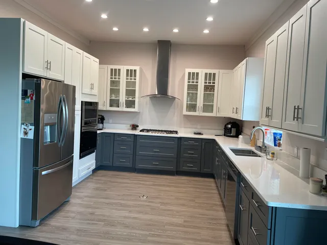 a large kitchen with granite countertop a large counter top stainless steel appliances and cabinets