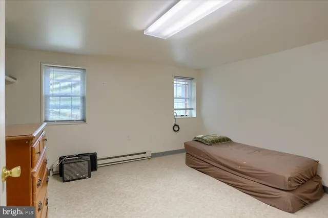 a bedroom with a bed chair and a window