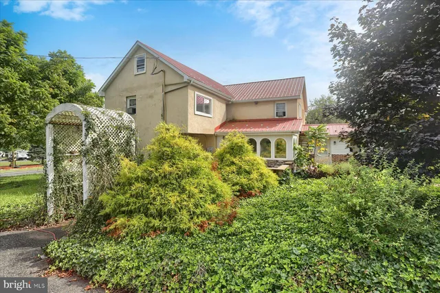 a front view of a house with a yard and shrubs