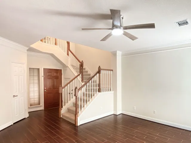 a view of a hallway with wooden floor and staircase