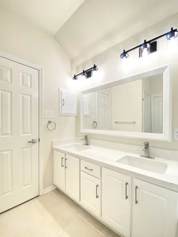 a bathroom with a sink double vanity and a mirror