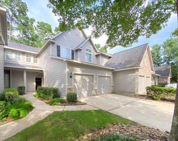 a front view of a house with a yard and potted plants