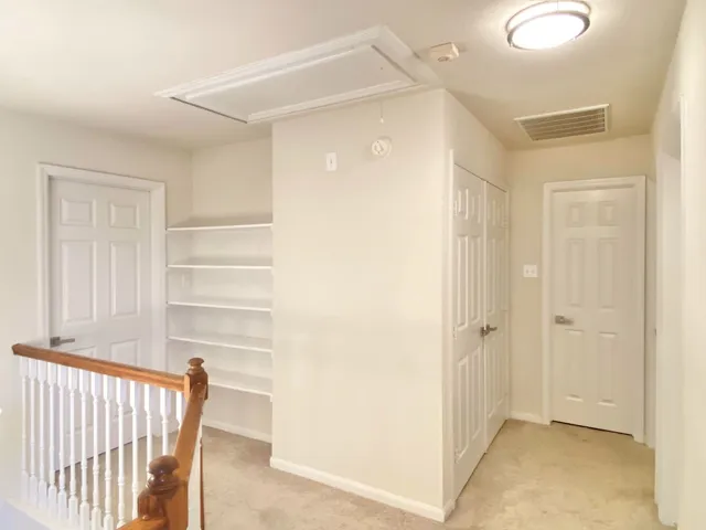 a view of a hallway with wooden shelves